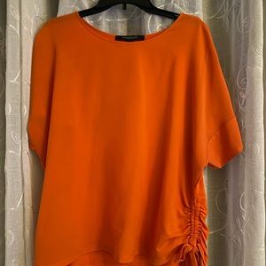 Orange blouse with a tied knot on the side